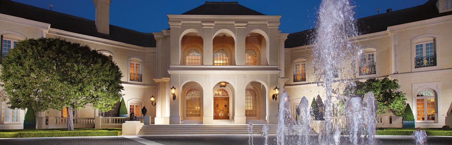 Grand luxury estate with fountain at twilight